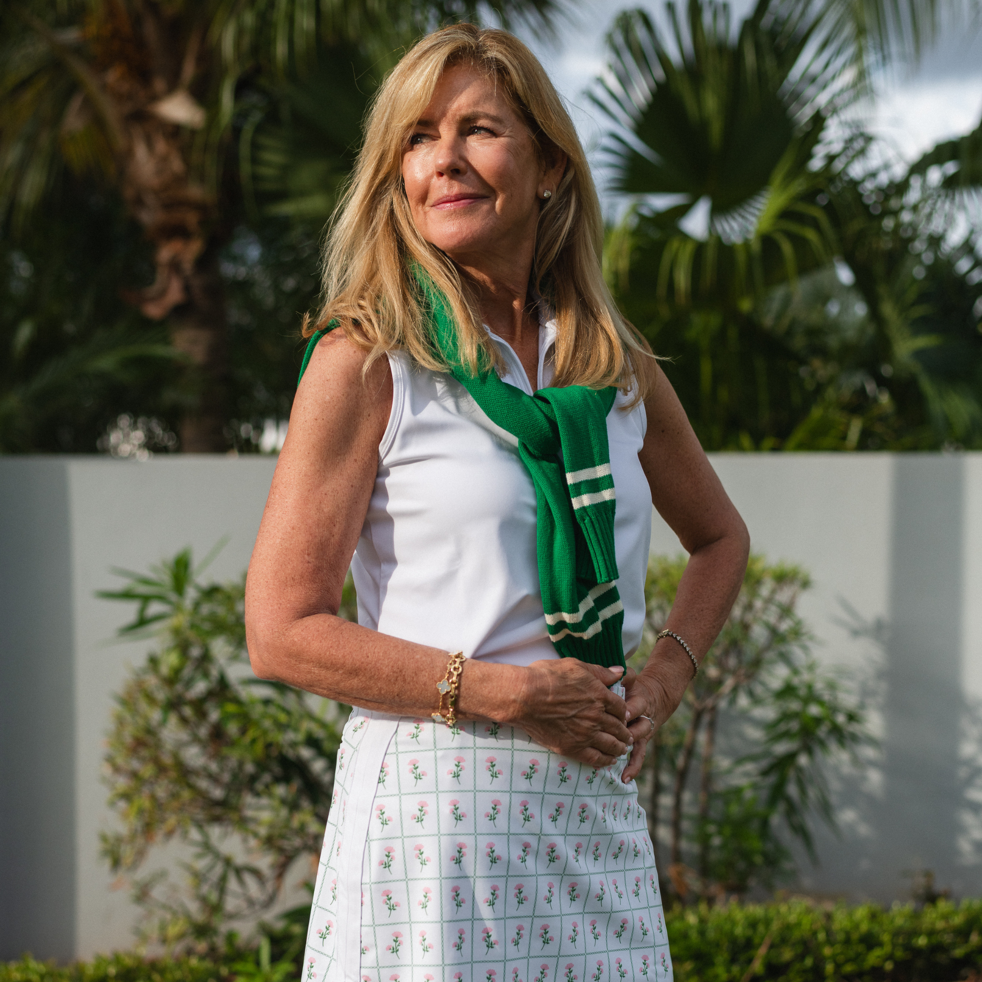 Woman wearing a green scarf with a white background and plants